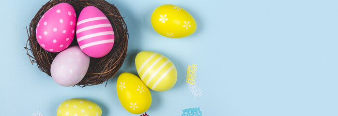 Fototapeta na wymiar happy easter. holidays background nest with easter eggs decoration on blue background. Banner
