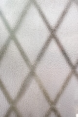 窓のすりガラス越しに眺める面格子の模様