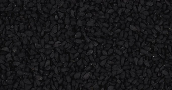 Top view of dried black cumin seeds rotating. Closeup. Macro.
