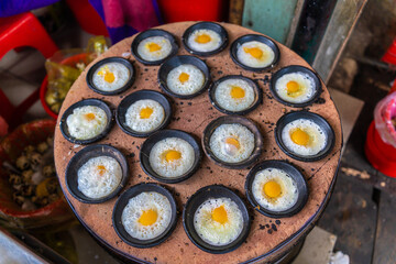Vietnamese Street Food in Da Lat city, Vietnam - Banh can on the warm ember stove kitchen. Food and travel concept.