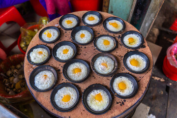 Vietnamese Street Food in Da Lat city, Vietnam - Banh can on the warm ember stove kitchen. Food and travel concept.