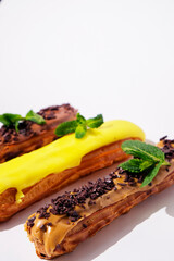 French eclairs with choclate top and different fillings. Traditional recipe, French cuisine.