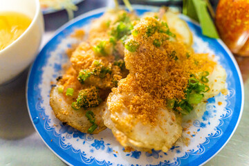 Vietnamese savory mini shrimp pancakes (Banh Khot) with herbs, eggs, shrimps and fish Sauce - Vietnamese cuisine.