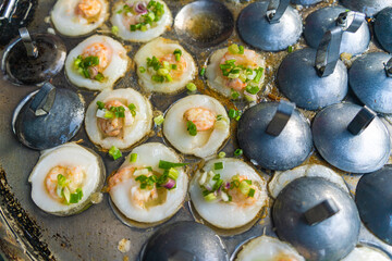 Vietnamese savory mini shrimp pancakes (Banh Khot) with herbs, eggs, shrimps and fish Sauce - Vietnamese cuisine.