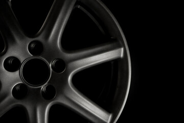 Gray alloy wheel or rim of a car on a black background close-up