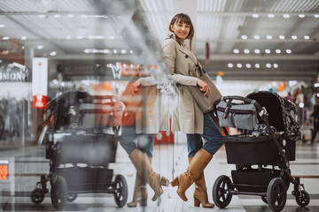 Young mother walking baby stroller in a shopping mall