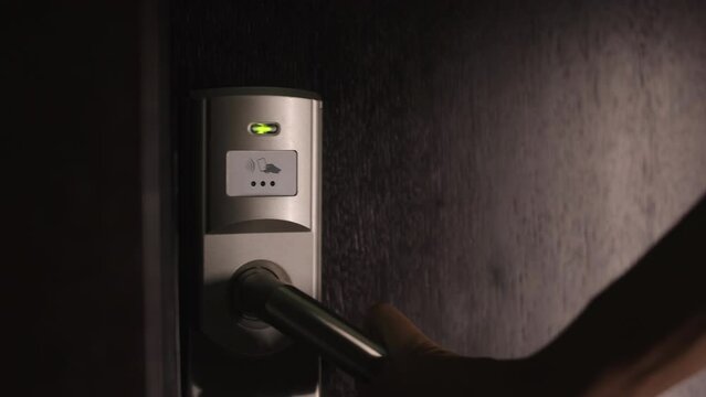 Female person using electronic keycard for opening door at modern hotel. Close up of woman entering her private room with security code.