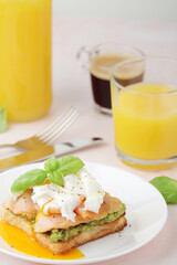 Breakfast with a sandwich with poached egg and avocado	