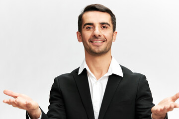a man in a black business suit shrug Marketing Manager successful look smile self-confidence white studio background, copy space