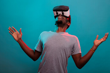 Male gamer looking up while he uses virtual reality headset with interactive technology and 3d...