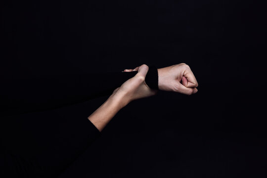 Caucasian hand holding clenched fist from abusing someone on black background. Domestic violence. Copy space Physical and psychological abuse, relative aggression, gaslighting.