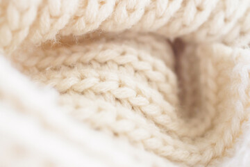 closeup beige knitted woolen fabric texture background