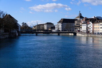 Fototapeta na wymiar View at the old town of Solothurn seen form the Kreuzacker Bridge on a sunny winter day with river Aare in the foreground. Photo taken February 7th, 2022, Solothurn, Switzerland.