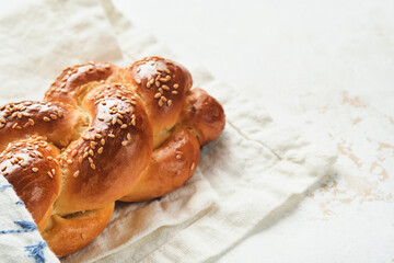 Challah bread. Sabbath kiddush ceremony composition. Freshly baked homemade braided challah bread for Shabbat and Holidays on white background, Shabbat Shalom. Top view. Copy space.