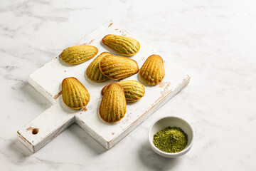 French madeleine cookies with matcha tea on the board. Menu concept. 