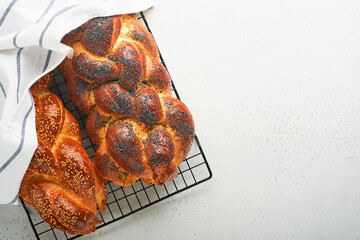 Challah bread. Sabbath kiddush ceremony composition. Freshly traditional baked homemade braided challah bread for Shabbat and Holidays on light grey background, Shabbat Shalom. Top view. Copy space. - obrazy, fototapety, plakaty