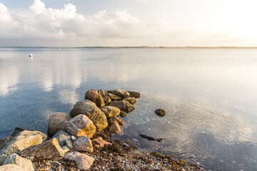 Rocks at a pebble beach at the calm Baltic sea in the peaceful morning light
