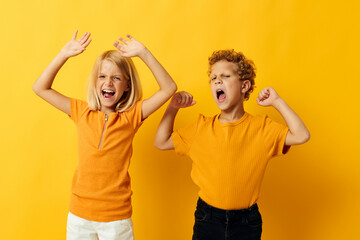 cheerful children in yellow t-shirts standing side by side childhood emotions yellow background