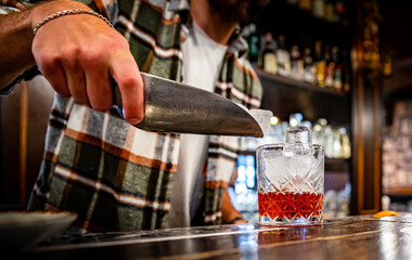 Fototapeta na wymiar man hand bartender making glass negroni cocktail in bar
