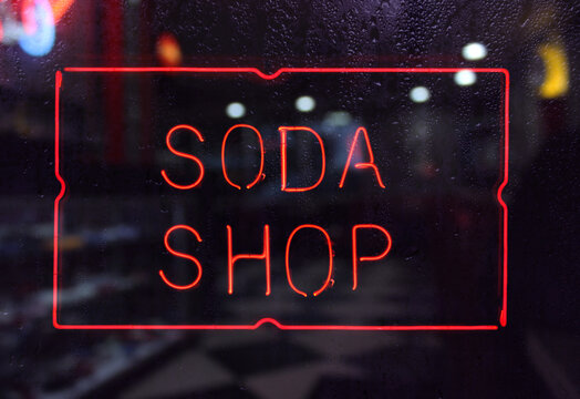 Vintage Neon Soda Shop Sign in Rainy Window
