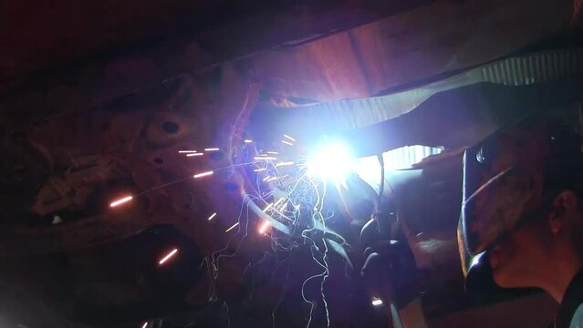 Welding a new catalytic converter onto an existing exhaust system.