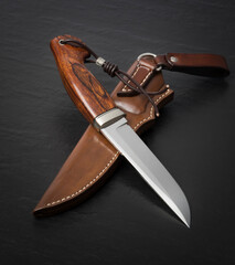 Hunting knife handmade on a black background.