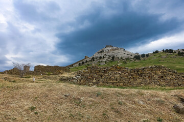 A picturesque view with a stormy sky of the Fortress Mountain and the ancient fortress. Genoese Fortress, Sudak, Crimea