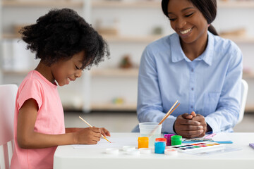 Cute african american little girl drawing at daycare