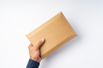Male hand holding parcel post against white background