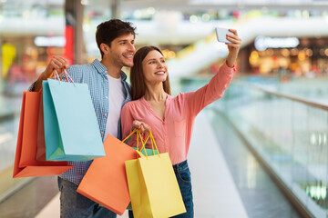 Cheerful Spouses Shopping Making Selfie Using Smartphone In Hypermarket