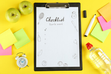 Sports Event Checklist. Flat lay composition with clipboard, alarm clock and bottle of water on yellow background