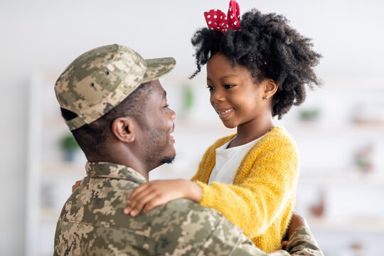 Happy Black Soldier Father And His Cute Little Daughter Embracing At Home