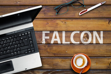 Falcon  Programming Language. Word Falcon on wooden desk and laptop