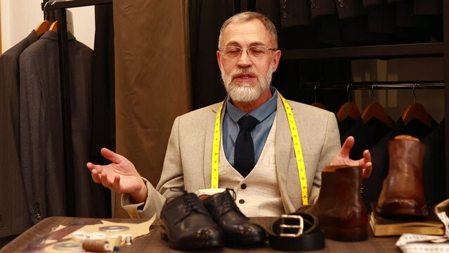 mature businessman presenting best type of stylish shoes talking to camera