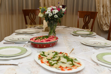 Table setting with dishes and tableware in stylish home interior.