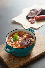 Asturiana fabada with haricot, blood sausage on brown background. Vertical format. Close up. Traditional Spanish warming dinner.