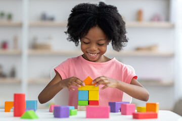 Little child playing with colorful wooden blocks