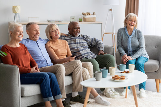 International Group Of Elderly People Watching TV At Nursing Home