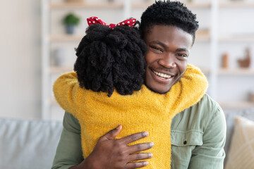 Little Daughter Embracing Happy Young African American Father At Home