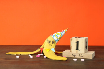 Concept of April Fool's Day on wooden table - obrazy, fototapety, plakaty