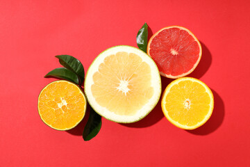 Citrus fruits with leaves on red background
