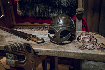 Viking chair and table with viking helmet and fighting sword. Ancient, vikings theme.