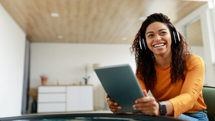 Portrait of smiling black woman using tablet at home