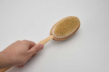 hand holding dry brush massager on white background