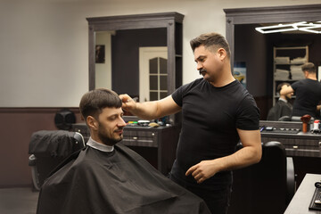 Professional hairdresser making stylish haircut in barbershop