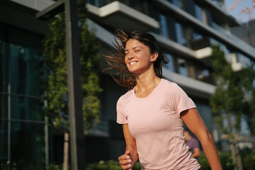 Fit athlete woman in sportswear outdoors. Young woman jogging outside..