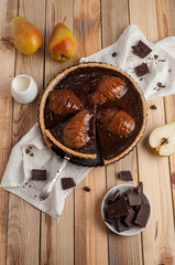 Tart with chocolate and pear on a light wooden background