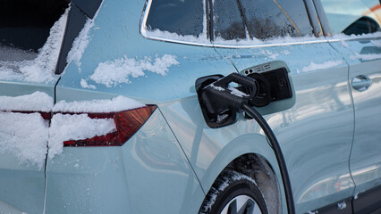 charging an electric car in winter.