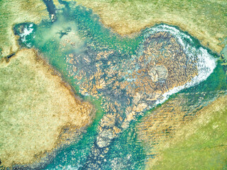 Top view of a heart-shaped lake in the middle of untouched nature.