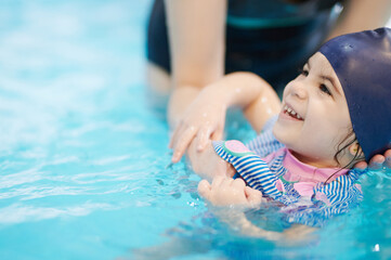 Happy kid learning to swim at school